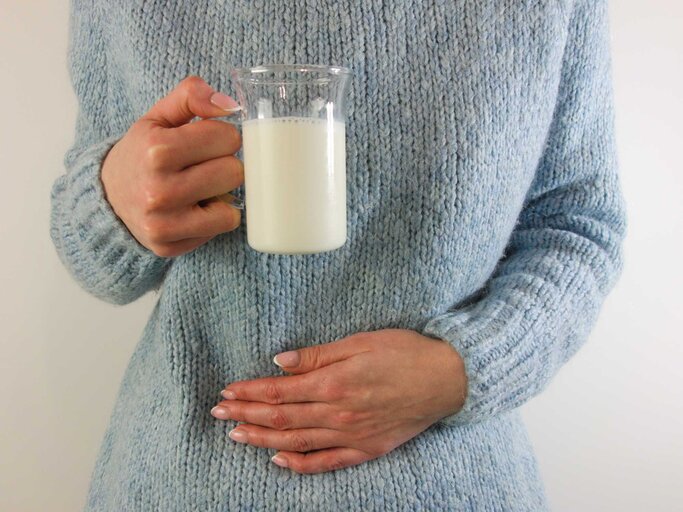 Frau mit Milchglas hält Hand auf Bauch | © Getty Images/Piotrekswat