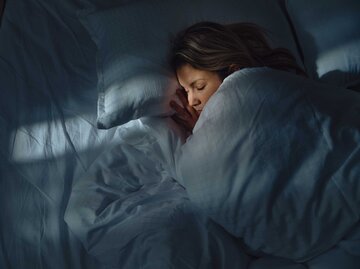 Frau schläft im Bett | © Getty Images/skynesher