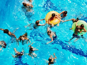 Viele Menschen im Wasser eines Schwimmbads | © GettyImages/Thomas Barwick