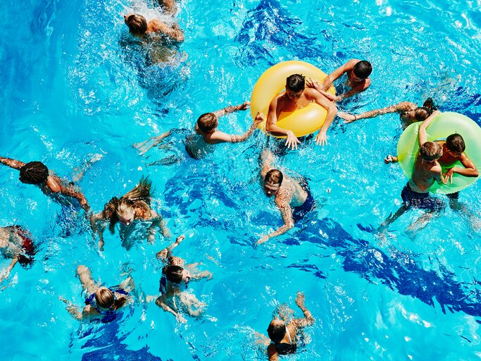 Viele Menschen im Wasser eines Schwimmbads | © GettyImages/Thomas Barwick