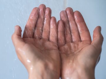 Schrumpelige Hände unter Dusche | © Getty Images/Vladimir Vladimirov
