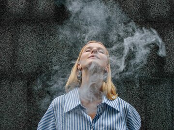 Junge Frau im Hemd ist umgeben von Rauch | © Getty Images/Artem Hvozdkov