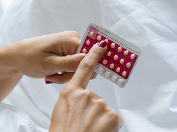 Frau hält Antibaby-Pille fest | © Getty Images/PhotoAlto/Frederic Cirou