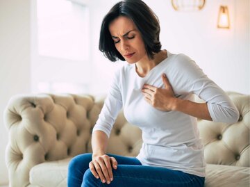 Frau greift sich schmerzerfüllt an die Brust | © Adobe Stock/Maksym Povozniuk