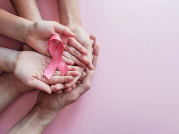 Hände von oben fotografiert, die eine pinke Schleife halten | © Adobe Stock/ SewcreamStudio