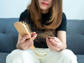 Person mit Bürste und ausgefallenen Haaren | © Getty Images/Boy_Anupong