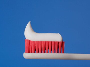 Zahnbürste mit pinken Borsten und Zahncreme | © Getty Images/Glowimages