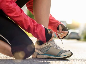 Frau bindet sich die Sportschuhe | © gettyimages.de /  Buero Monaco