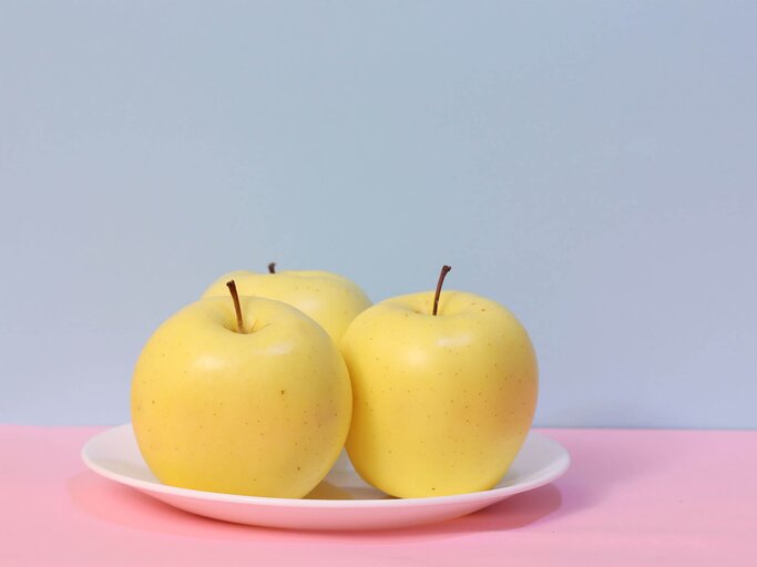 Apfel auf blauem und rosafarbenem Hintergrund | © Getty Images/mssh3986