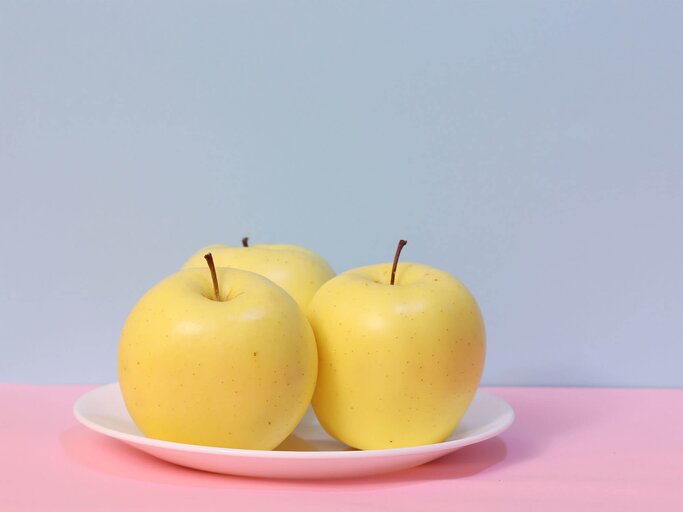 Apfel auf blauem und rosafarbenem Hintergrund | © Getty Images/mssh3986