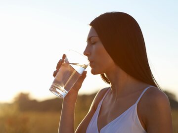 Frau trinkt aus einem Glas Wasser | © Getty Images/Dougal Waters