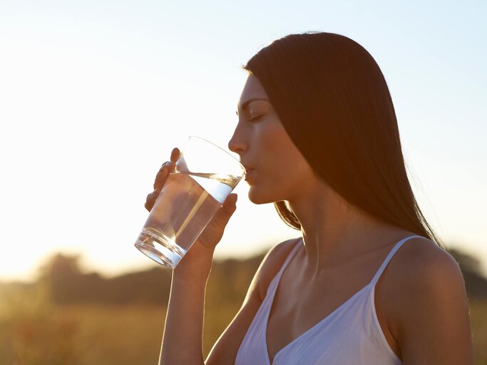 Frau trinkt aus einem Glas Wasser | © Getty Images/Dougal Waters