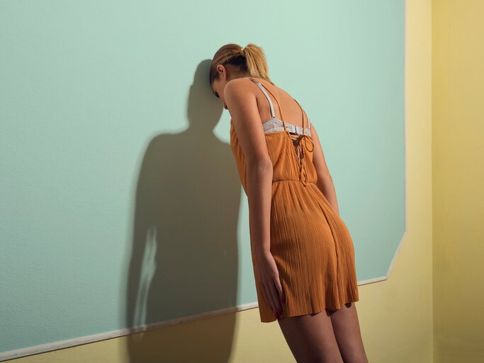 Frau lehnt sich gegen die Wand | © Getty Images/Francesco Carta fotografo
