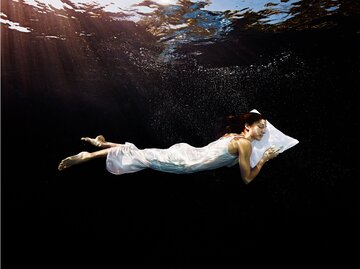 Frau schläft auf dem Bauch im Wasser | © Getty Images/Thomas Barwick