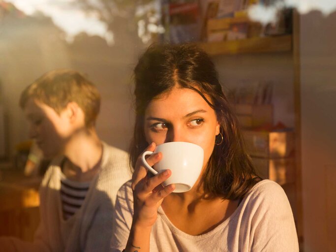 Junge Frau sitzt im Café und trinkt eine Tasse Kaffee. | © Getty Images / Betsie Van der Meer