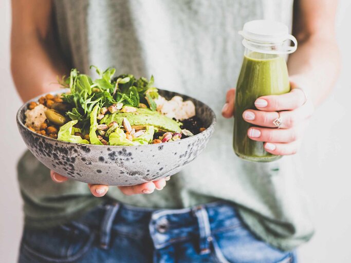 Frau in Jeans mit Superbowl und Smoothie | © Getty Images/Foxys_forest_manufacture