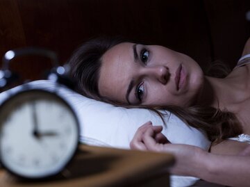 Frau liegt schlaflos nachts im Bett | © Getty Images/KatarzynaBialasiewicz