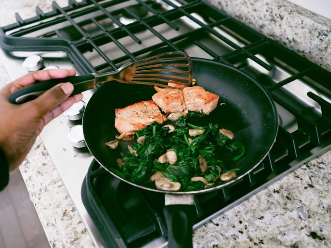 Spinat zusammen mit Lachs in einer Pfanne | © Getty Images/Grace Cary