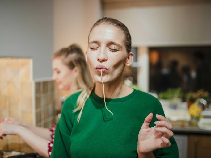 Junge Frau schlürft genußvoll eine Spaghetti | © Getty Images/DGLimages