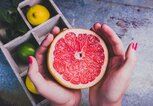 Frau hält eine aufgeschnittene Grapefruit in den Händen | © Getty Images/npdesignde