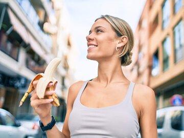 Frau hält Banane in der Hand  | © Getty Images/AaronAmat