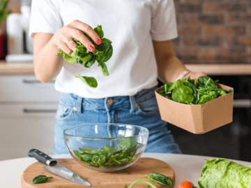 Frau streut Salat in eine Schüssel | © Getty Images/Mariia Skovpen