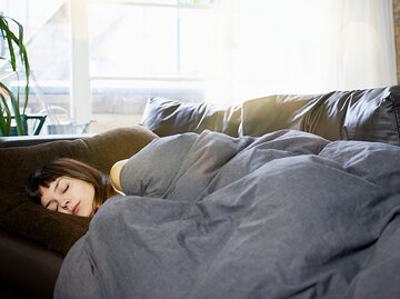 Eine junge Frau schläft immer auf dem Sofa ein | © GettyImages/Tara Moore