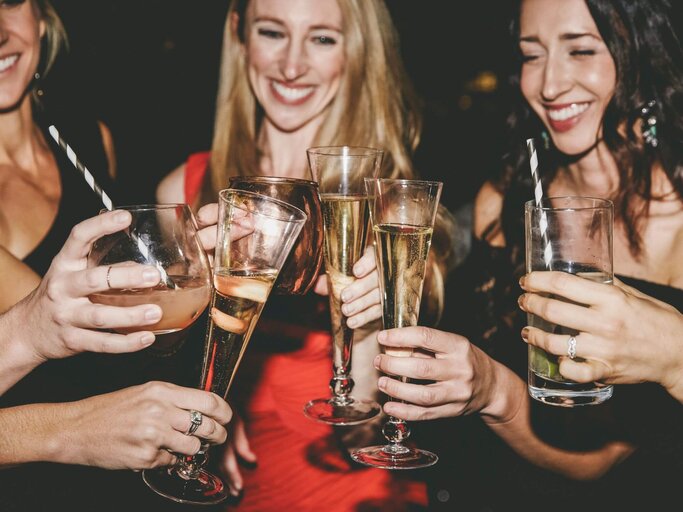 Personen stoßen auf Party mit Alkohol an | © Getty Images/The Good Brigade