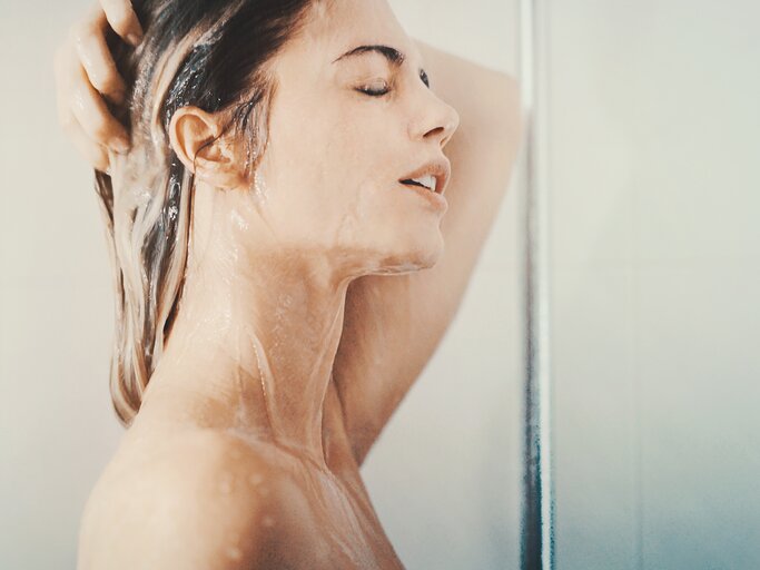 Eine Frau duscht sich kalt | © GettyImages/gilaxia