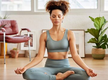 Person bei Meditation auf Yoga-Matte | © Getty Images/Morsa Images