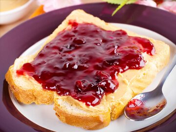 Eine Scheibe Toast mit roter Marmelade. | © Adobe Stock / Martin Rettenberger