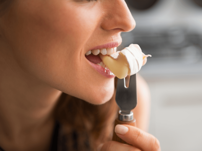 Frau isst Käse mit einer Gabel | © Getty Images/CentralITAlliance