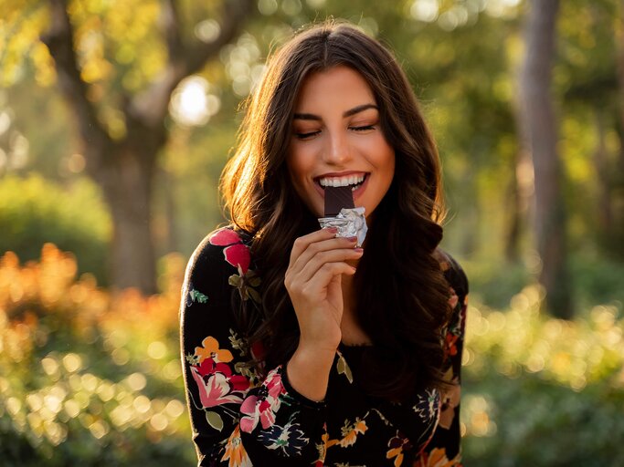 Frau isst im Freien Schokolade | © Getty Images/Phoenixns