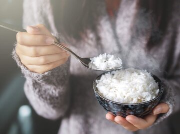 Frau hält Schale voll Reis und einen Löffel in der Hand | © Getty Images/Chaiwat Hemakom / EyeEm