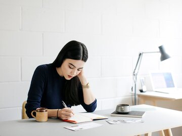 Frau sitzt im Büro am Schreibtisch | © Getty Images/Alys Tomlinson