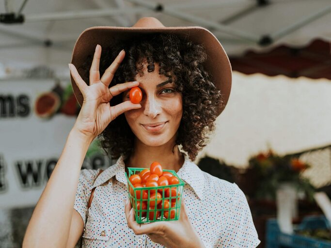 Frau mit Hut und Körbchen Tomaten | © Getty Images/Rawpixel