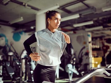 Entschlossene athletische Frau, die auf dem Laufband läuft | © Getty Images/Drazen Zigic