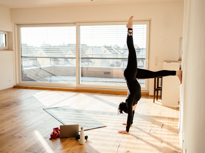 Eine junge Frau macht eine Übung aus Wand-Pilates | © GettyImages/Anna Mardo