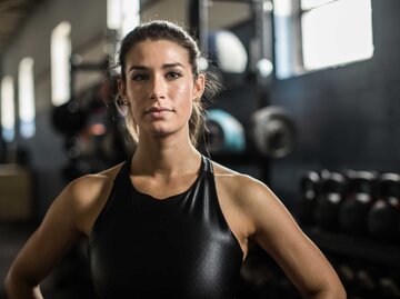 Junge Frau mit selbstbewusstem Blick im Fitnessstudio | © Getty Images/MoMo Productions