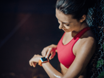 Frau schaut auf Fitness-Tracker | © Getty Images/Guido Mieth