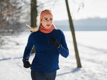 Junge Frau joggt bei Eis und Schnee im Freien | © Getty Images/Westend 61