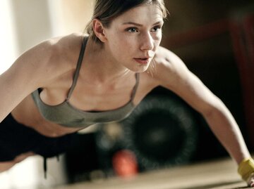 Eine junge Frau macht Liegestütze in einem Fitnessstudio | © Willie B. Thomas