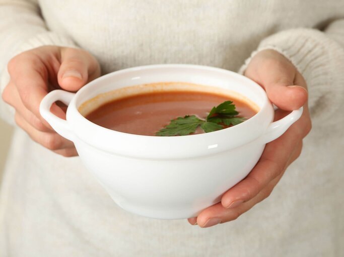 Frau hält Schale mit roter Suppe in den Händen | © Getty Images/AtlasStudio