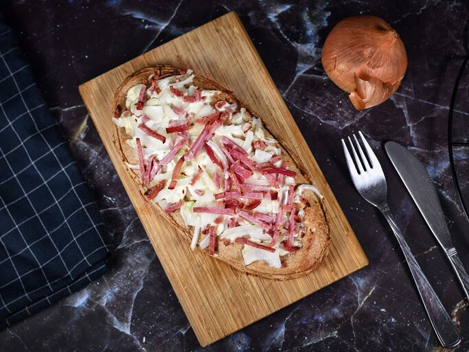 Flammkuchen auf Holzbrett | © Getty Images/Firn