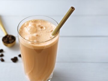 Kaffeeprotein Milchshake Smoothie steht auf einem weißen Tisch. | © shutterstock/Y.P.photo