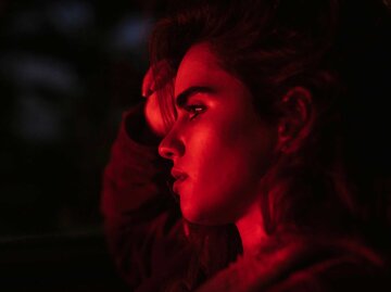 Frau in rotem Licht beleuchtet | © IMAGO / Westend61