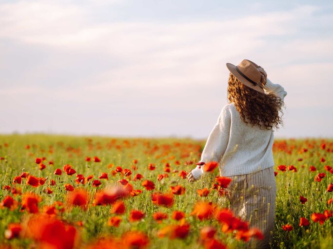 Frau auf Blumenwiese im Frühling | © Adobe Stock/maxbelchenko