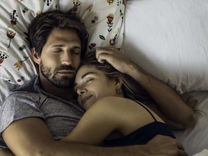 Mann und Frau kuscheln gemeinsam im Bett | © Getty Images/PhotoAlto/Frederic Cirou