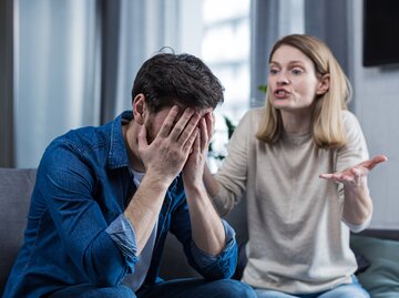 Frau schreit Mann an, während er seine Hände vor das Gesicht hält | © Getty Images/Liubomyr Vorona