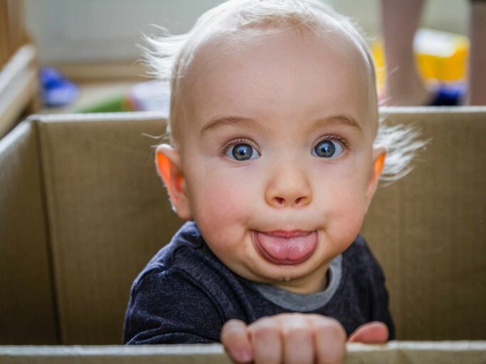 Freches Baby schaut in die Kamera und streckt die Zunge raus | © Getty Images/dm909